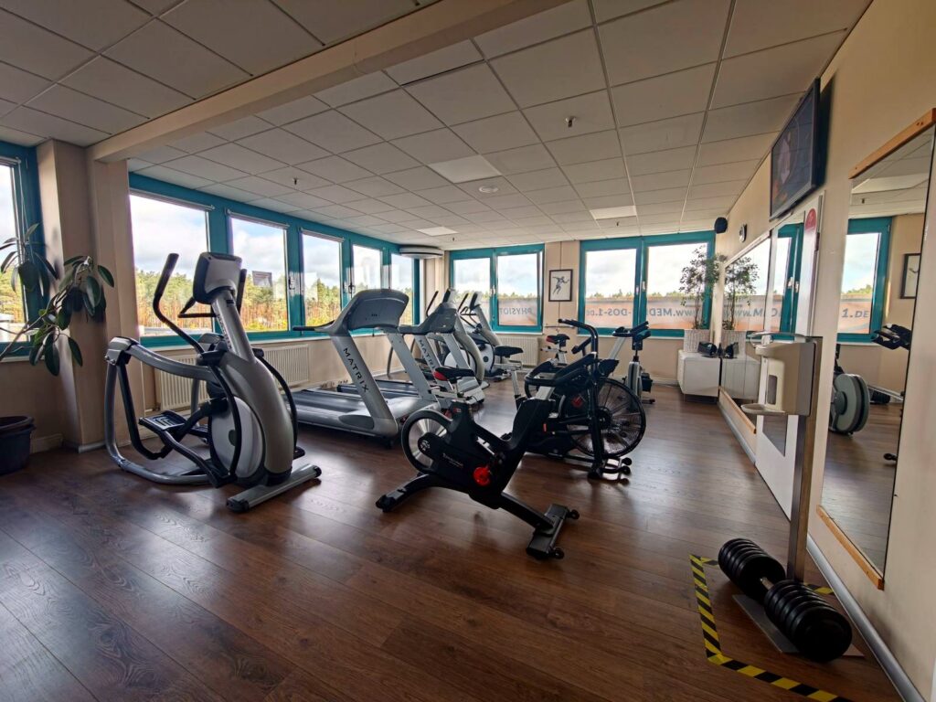 Trainingsfläche mit Ergometern und Crosstrainer vor einer Fensterfront