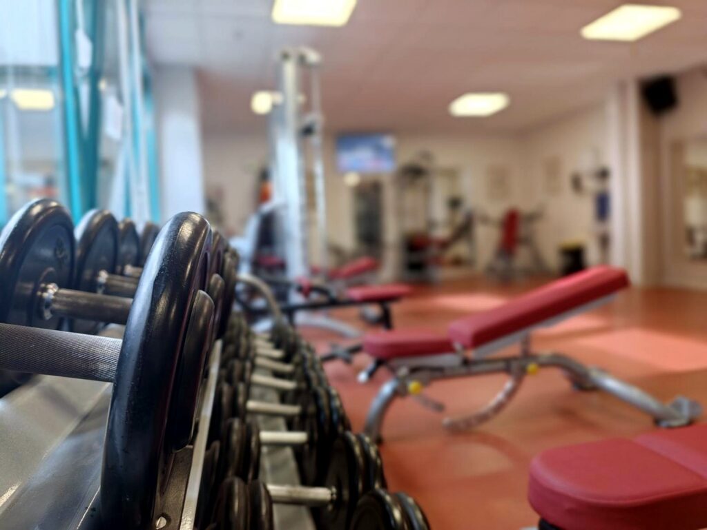 Kurzhanteln und Trainingsbank im Kraftbereich der Praxis