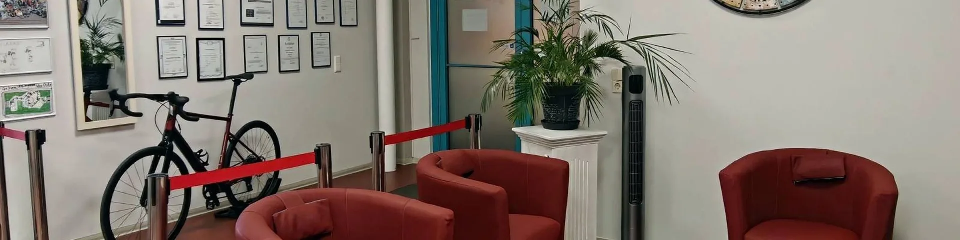 Wartebereich mit Sesseln und Urkundenwand